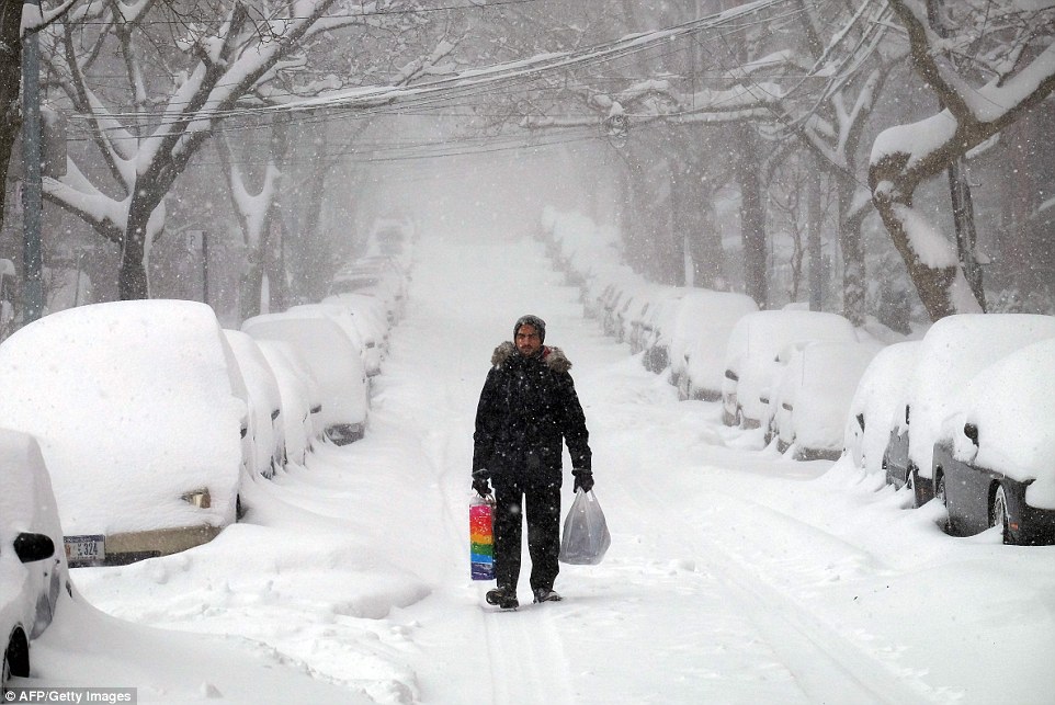3081E8BB00000578-3413634-A_man_makes_his_way_during_a_storm_in_New_York_while_across_the_-a-80_1453624634275