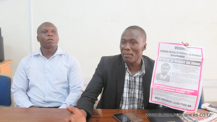 2.Mwinjilisti,Daudi  Mashimo (kulia) akionesha moja ya karatasi aliyoindaa yenye ujumbe ambayo alisema atabandika kwenye mabango ya matangazo .