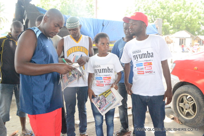 2.Wasomaji wa Gazeti la Uwazi eneo la Stendi ya daladala ya Vikindu wakijaza kuponi zao kushiriki droo ya Shinda Nyumba.