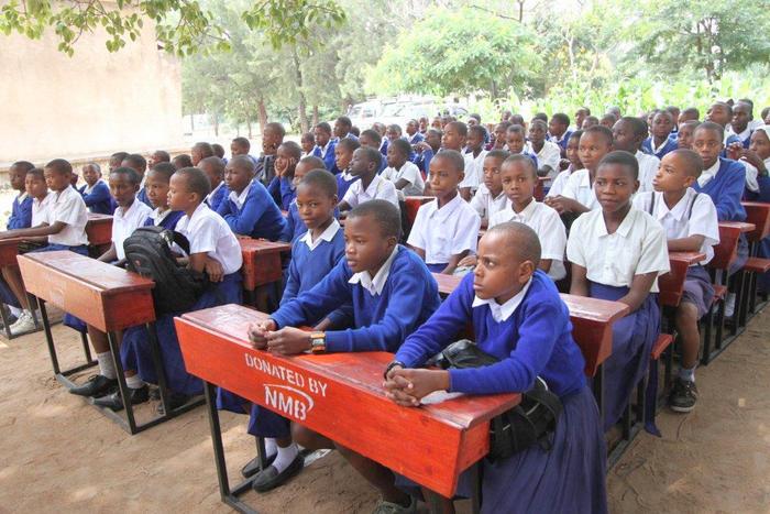 WANAFUNZI SHULE YA KIOMBOI BOMANI WAKIWA WAMEKALIA MADAWATI