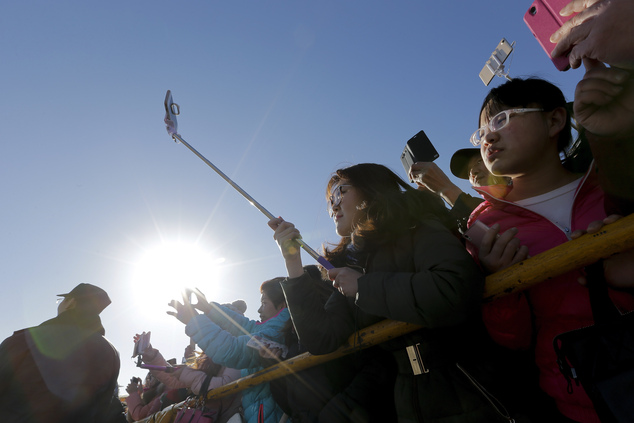 People watch an ancient Qing Dynasty ceremony in which emperors prayed for good harvest and fortune at a temple fair in Ditan Park during the first day of the Chinese Lunar New Year in Beijing, Monday, Feb. 8, 2016. Millions of Chinese began celebrating the Lunar New Year, which marks the Year of Monkey on the Chinese zodiac. (AP Photo/Andy Wong)