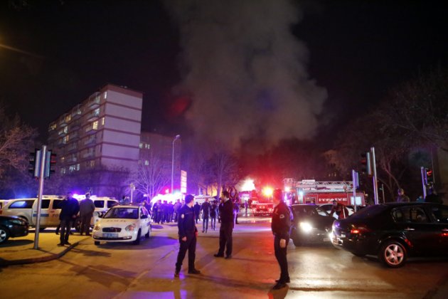 Smoke from a fire billow is seen following an explosion as police officers secure the area in Ankara, Wednesday, Feb. 17, 2016. A large explosion, believed to have been caused by a bomb, injured several people in the Turkish capital on Wednesday, according to media reports. (Cihan News Agency via AP)