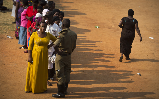 Ugandans queue up to cast their votes at a polling station that had not received any voting materials on election day, in Ggabe, near Kampala, in Uganda Friday, Feb. 19, 2016. Police in Uganda arrested opposition leader Kizza Besigye at his party's headquarters Friday after heavily armed police surrounded the building and fired tear gas and stun grenades at his supporters who took to the streets. (AP Photo/Ben Curtis)
