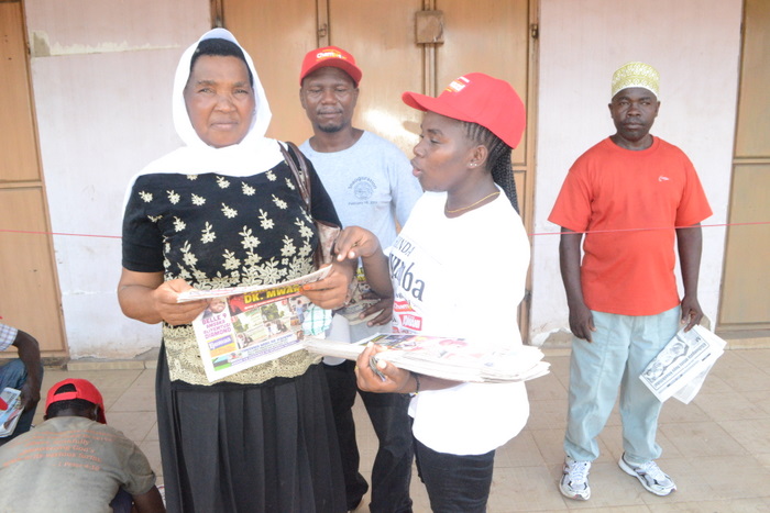 10.Mwanamama, SalamaSalum (kushoto) akipata maelekezo kutoka kwa muuzaji wa magazeti ya Global,Theresia Julian (kulia) kabla ya kujaza kuponi yake.