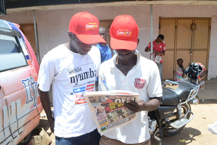 14. Ofisa Masoko wa Global,Yohana Mkanda (kushoto) akishuhudia msomaji wa Amani akijaza kuponi yake.