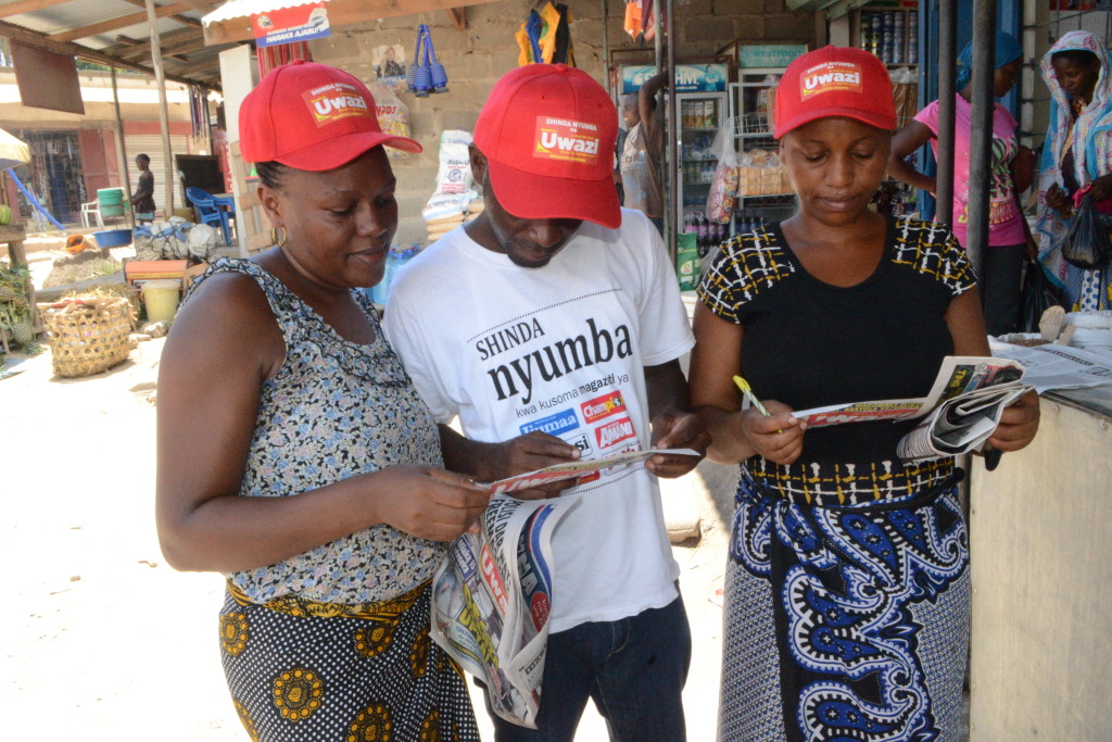 2.Ofisa Masoko wa Global,Yohana Mkanda (katikati)akikagua kuponi kama zimejazwa ipasavyo na wasomaji wa Gazeti la Uwazi, Joyce Mghase (kushoto) na Theodora David.