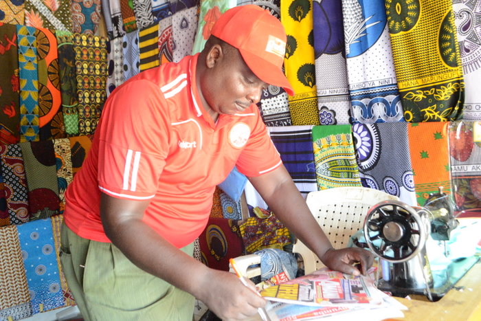 7.Mdau wa Gazeti la Amani anayefanya shughuli zake za kuuza vitenge na Khanga katika maeneo ya Mlandizi, Peter P.Marwa akiliangalia gazeti lake ukurasa wa mbele mara baada ya kujaza kuponi yake.