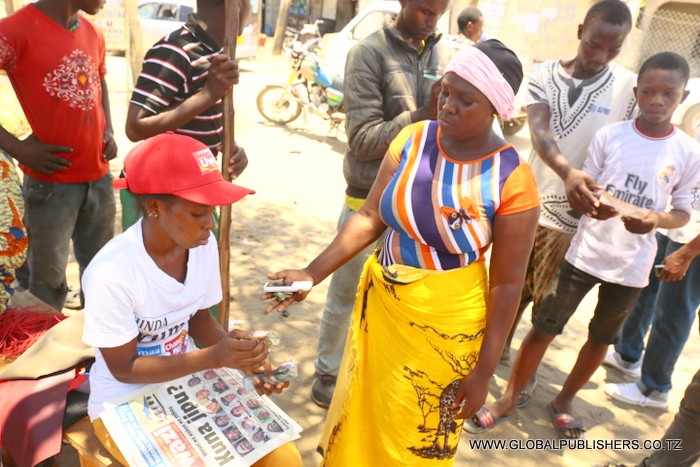 Aisha Bakari mkazi wa Boko magengeni akinunua gazeti kutoka kwa muuza magazeti wa Global publishers-001