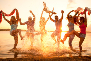 Large-group-of-young-people-enjoying-a-beach-party_147047612