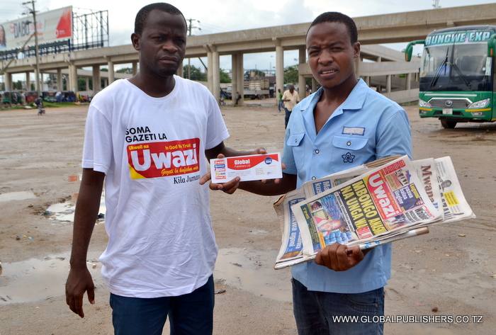 10 Muuzaji wa magazeti eneo la Ubungo Stendi ya Mabasi akipokea kuponi yake maalum ya zawadi baada ya kukutwa akiweka juu Gazeti la Uwazi.