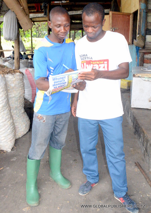 9.Msomaji (kushoto) akijaza kuponi yake.
